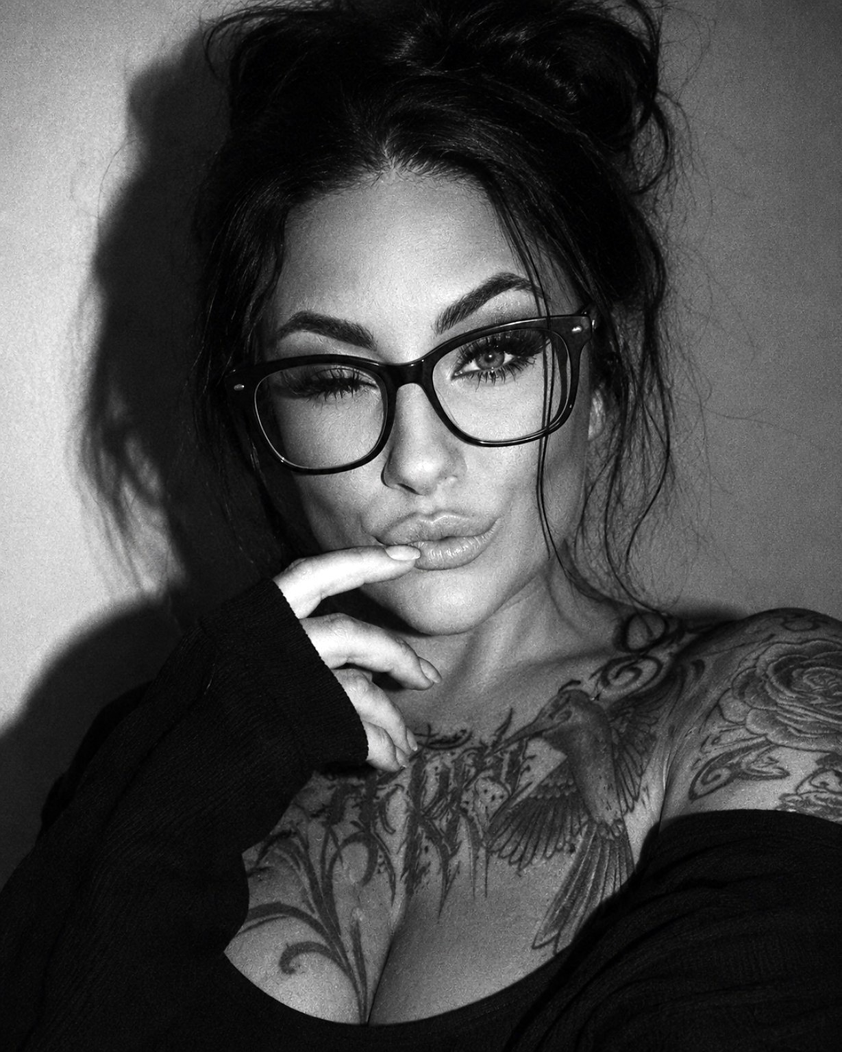 Nahes Schwarzweißporträt von Jasmin Jenny mit Brille und dunklem Oberteil